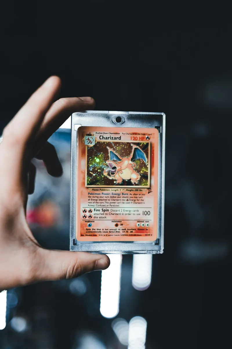 Tay cầm lá Charizard đặt trong hộp nhựa cứng trong suốt